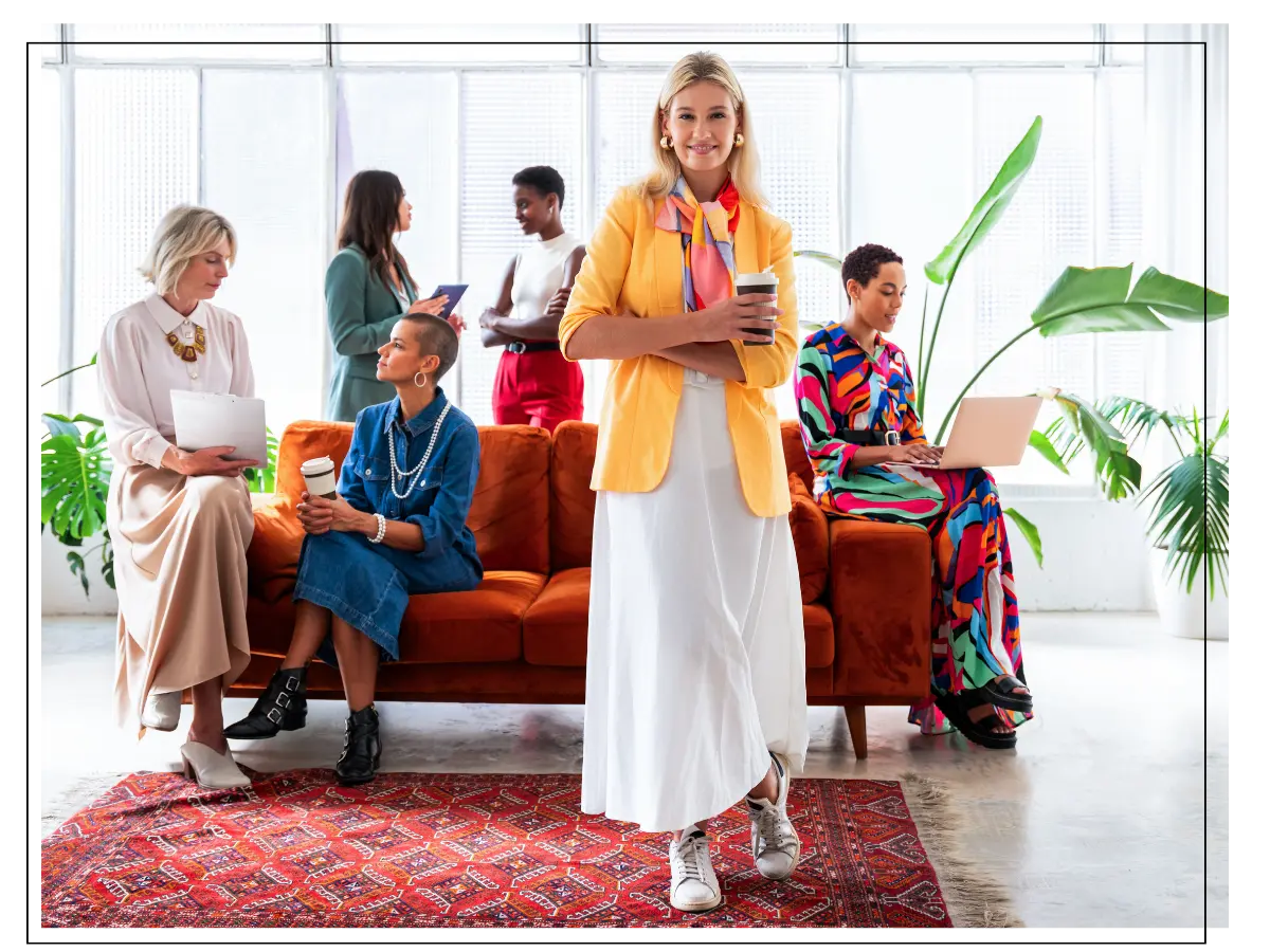 Female executive in white skirt and orange blazer holding cup of coffee after image consulting session