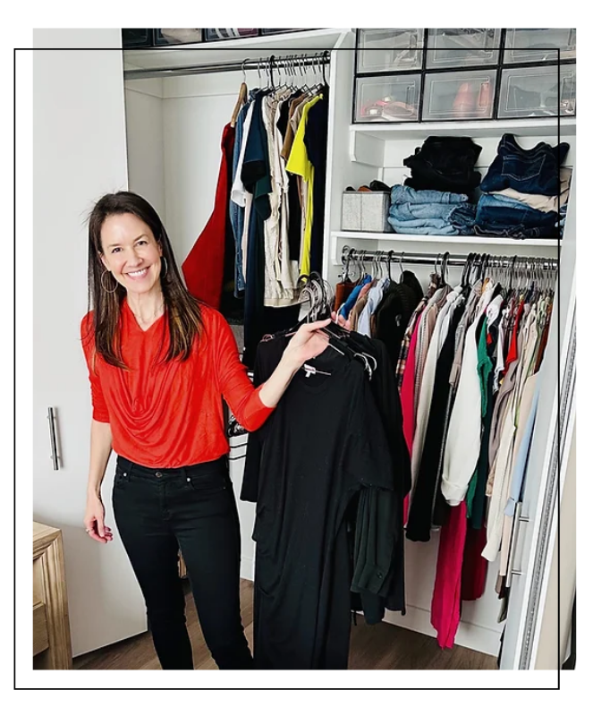 Martha Magriñá holding up woman's wardrobe in a closet while providing image consulting services