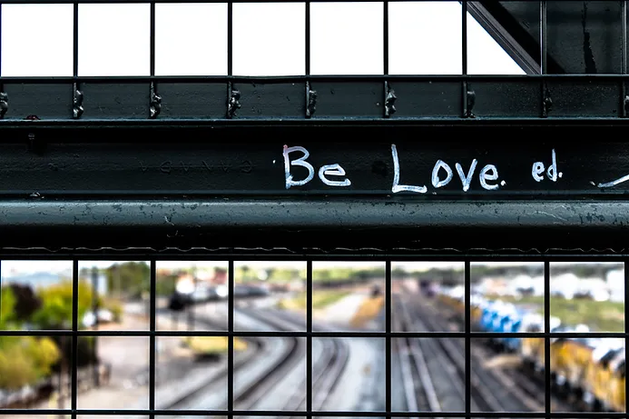 overpass with "be loved" written in white