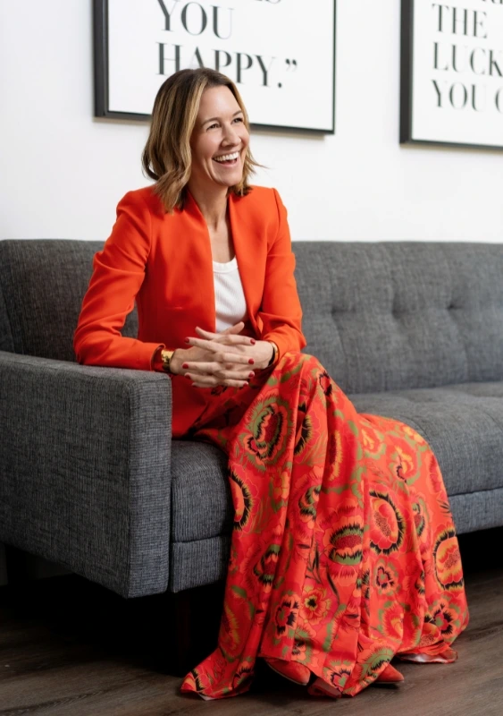 martha magrina image consultant in westchester ny sitting on a couch in pink skirt